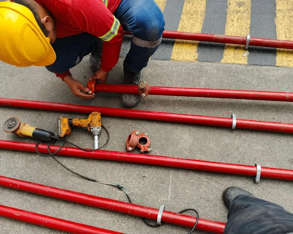 Técnicos ensamblando tuberías CI en edificio